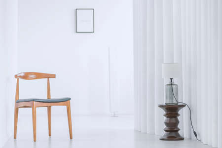 Simple wooden chair and vintage stool standing in a bright hallの写真素材