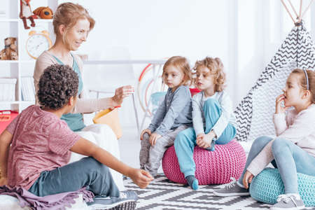 Multicultural group of children learning words during classes with teacher in nursery schoolの写真素材