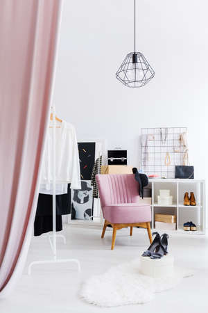 White and spacious, walk-in dressing room with pink curtain and armchairの写真素材