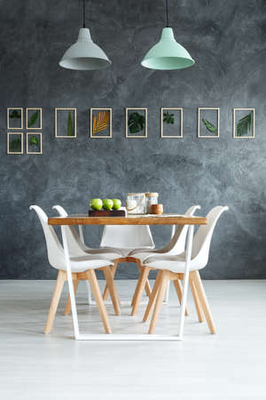  Wooden table styling with simple natural decorations in dining room with handmade botanical on gray...