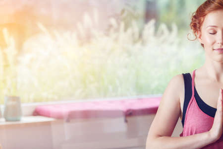 Copy space of young calm woman meditating at homeの写真素材