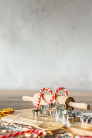 Kitchen tools, cake forms and candles on wooden board during christmas cookingの写真素材