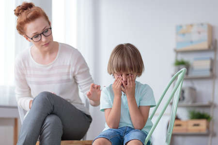 Parenthood and child development, young worried mother comforting little son crying at home