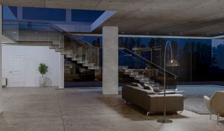 Side view of glass staircase in concrete house with big windows at night. 3D rendering.