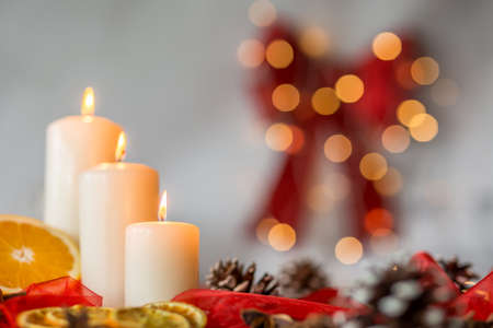 Close-up of white candles and orange as christmas time decorationの写真素材