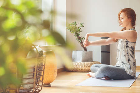 Caucasian woman stretching her hands, warming-up for yoga classの写真素材
