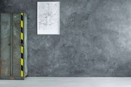 White map in frame on dark concrete wall in empty room with industrial shelf, copy space interior concept の写真素材