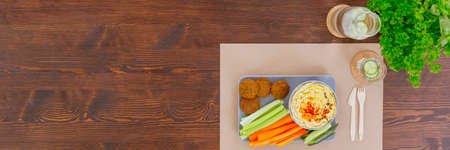 Healthy meal for a vegetarian. Falafel, hummus with vegetables and cucumber waterの写真素材