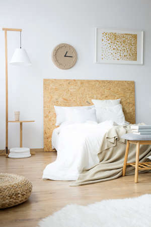 Messy bedsheets lying on a king size bed in a modern, monochromatic bedroom interiorの写真素材