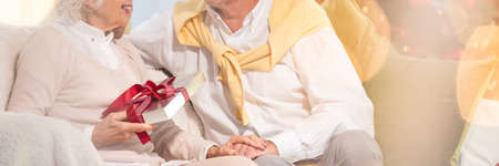 Woman keeping the christmas gift from her husbandの写真素材