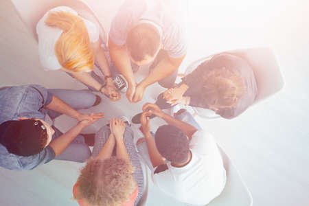 High angle of young people sitting in a circle during an appointment with therapistの写真素材