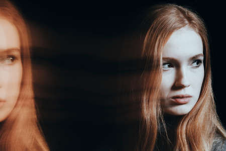 Suffering girl with psychosis and split personality. Photo of blurred and multiple faces against...