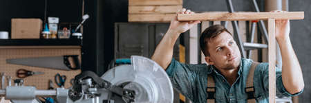 Ambitious employee performing woodwork joining together two pieces of woodの写真素材