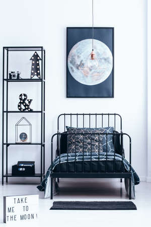 Copper lamp above child's bed in modern bedroom interior with lights on shelves and moon poster on white wallの写真素材