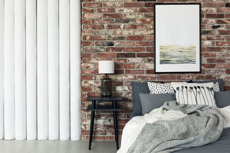 Abstract painting hanging on a brick wall in a flat interiorの写真素材