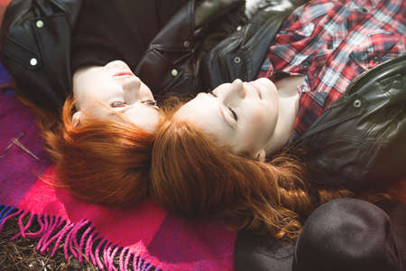 High angle of lesbian girls lying together on a blanketの写真素材