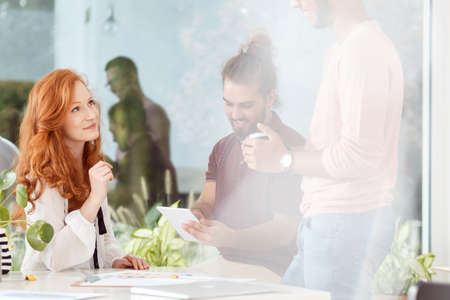 Businesswoman listening to an idea of her employee in the officeの写真素材