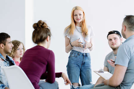 Young woman standing and introducing herself to the group during workshops