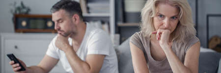 Worried and sad wife feeling lonely because of her husband cheating herの写真素材