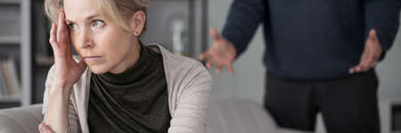 Tired woman and her jealous husband arguing with her. Problematic marriage conceptの写真素材