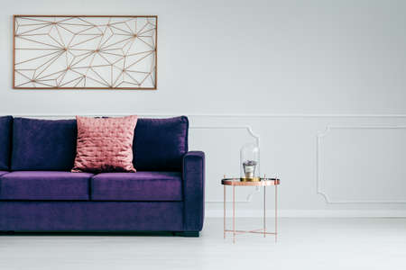 Ultra violet sofa and metal side table in empty living room interiorの写真素材