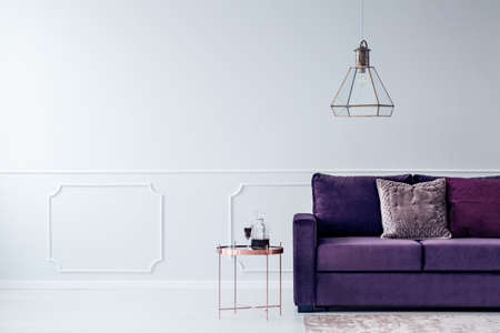 Cropped shot of a purple couch, metal side table and modern chandelier in waiting hall interiorの写真素材