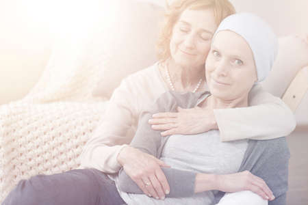 Flare photo of two women hugging and spending time togetherの写真素材