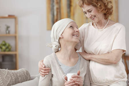 Woman with cancer celebrating disease remission with her motherの写真素材