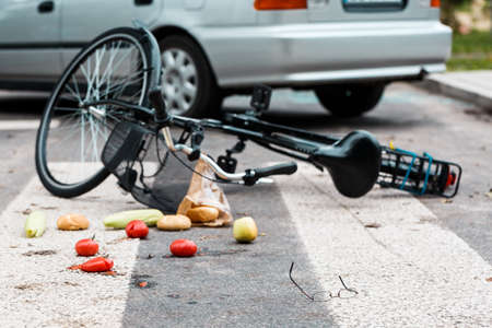 Car accident concept. Bicycle, broken glasses and groceries lying on the pedestrian crossingの写真素材