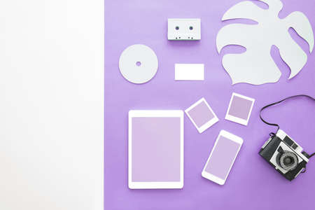 Travel blogger concept - business card with a tablet, smartphone and film camera on an ultra violet backgroundの写真素材