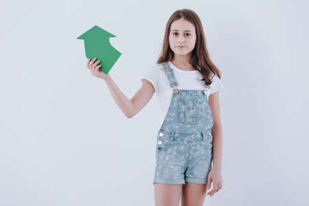 Girl holding a paper arrow as a sign of recycling on white background