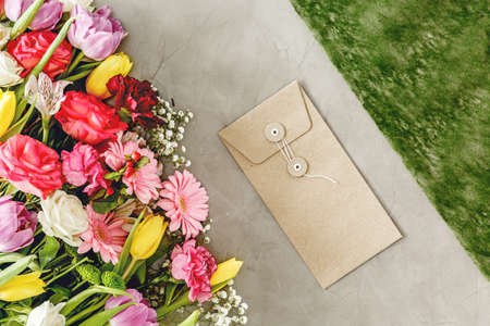Natural envelope next to colorful flowers on a florist's worktable before valentine's dayの写真素材