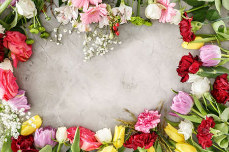Beautiful, colorful flowers lying around a gray table. Mother's day gift concept.の写真素材