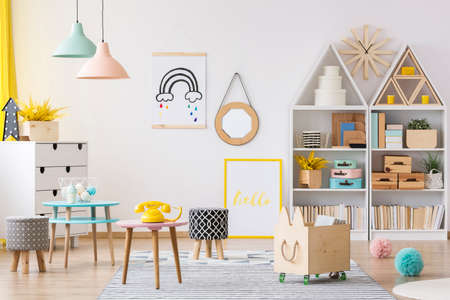 Patterned stool and wooden box in colorful child's playroom interior with a mirror on the wallの写真素材