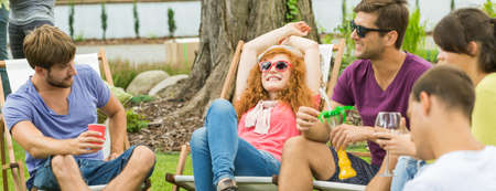 Young happy people chilling and having drinks in the countrysideの写真素材