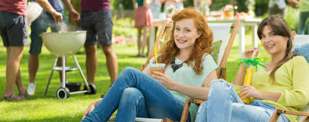 Girls with drinks chilling on sunbeds in the countrysideの写真素材