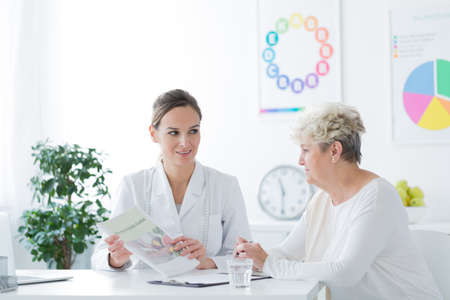 Woman sitting in a general doctor's office during medical interviewの写真素材