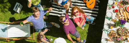 Young people dancing, drinking and eating at a party outdoorsの写真素材