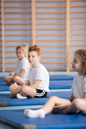 Side view of pupils in sportswear during training at the school gym