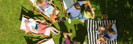 Friends spending time in a garden together dancing and restingの写真素材