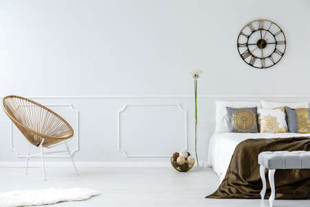 Gold bedroom interior with modern armchair, double bed and wall moldingの写真素材