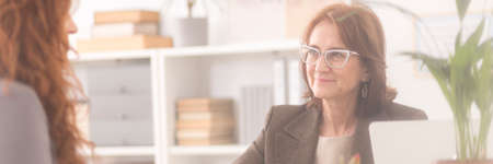 Smiling personal coach talking to her red haired patient