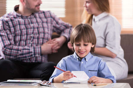 Close-up of smiling boy drawing a picture during therapy for autistic kidsの写真素材