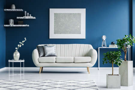 White and blue living room interior with a sofa, painting and plants in square potsの写真素材