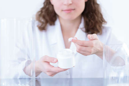 Close-up of laborer testing a face cream in a factoryの写真素材