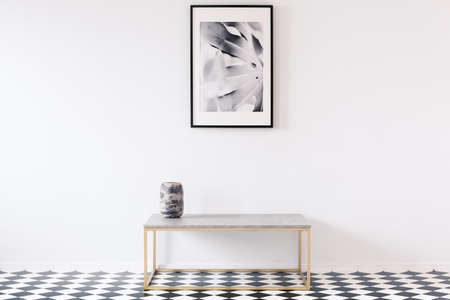 Minimalist black and white apartment interior for an artist with a luxurious golden bench and a...