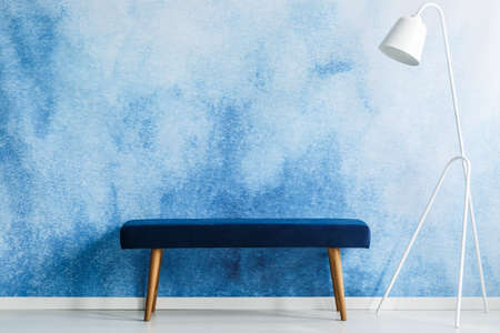 Blue bench and white lamp set on aquarelle wall in a waiting room interior. Place your productの写真素材