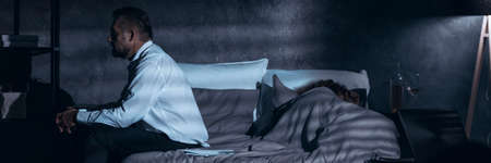 Panorama of a nervous man thinking about divorce while his wife is asleepの写真素材