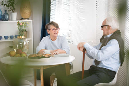 Elderly woman talking to a grandfather with a walking stickの写真素材