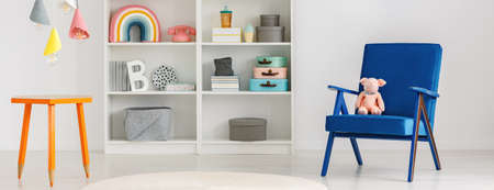 Colorful ice cream cones pendant lamps above a table with crayon legs in a fun and creative kid bedroom interiorの写真素材